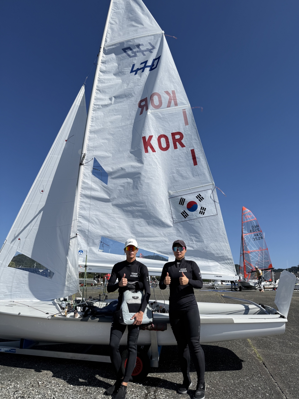요트 국가대표 김창주와 이경진이 2일 일본 아이치현 가마고리 가이요 요트 항구에서 열린 2026 아이치·나고야아시안게임 요트 혼성 딩기 경기 종료 후 기념사진을 찍고 있다. 2026.10.2 대한요트협회 제공