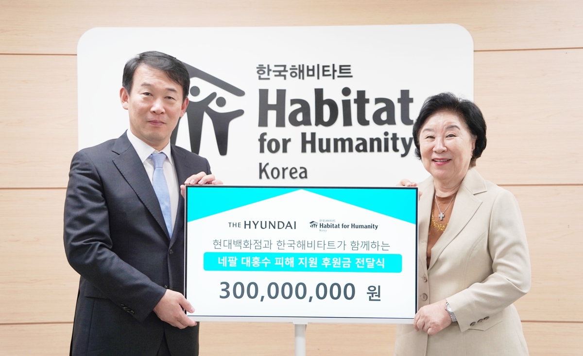 양명성(왼쪽) 현대백화점 영업전략담당 상무와 마희자 한국해비타트 이사장이 지난 2일 서울 중구 해비타트 본사에서 진행된 네팔 수해 복구 성금 전달식에서 기념사진을 찍고 있다. 현대백화점 제공