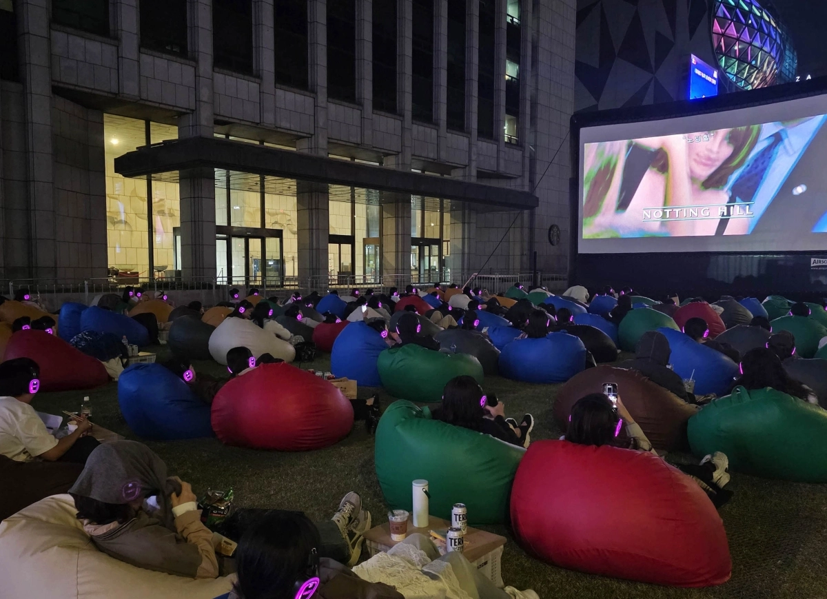4일 서울 중구 한국프레스센터 앞 서울마당에서 열린 ‘광화문 사일런트 시네마’에서 관람객들이 영화 ‘노팅힐’을 감상하고 있다. 3~4일 열린 행사에는 3500여팀이 신청해 200팀(400명)이 선정됐다. 2026.10.4 홍윤기 기자