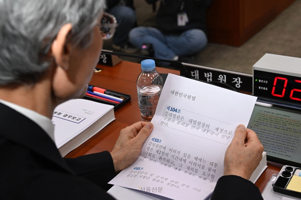 조희대 대법원장이 6일 국회 법제사법위원회에서 열린 대법원 등에 대한 국정감사에서 김기표 더불어민주당 의원의 질의를 듣던 도중 미리 준비해 온 A4 용지를 꺼내들고 대법관 재제청 논란에 대한 입장을 밝히고 있다. A4 용지에는 대법관 제청 및 국정감사와 관련된 헌법 조문이 정리돼 있다. 홍윤기 기자