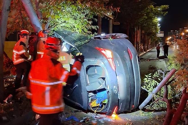 7일 0시쯤 전남광주 서구 매월동 풍암사거리 인근 왕복 6차로 도로에서 스포츠유틸리티차(SUV)가 인도 경계석을 받으면서 가로수 및 가로등과 충돌해 전도됐다. 이 사고로 30대 운전자가 숨졌다. (전남광주통합소방본부 제공)