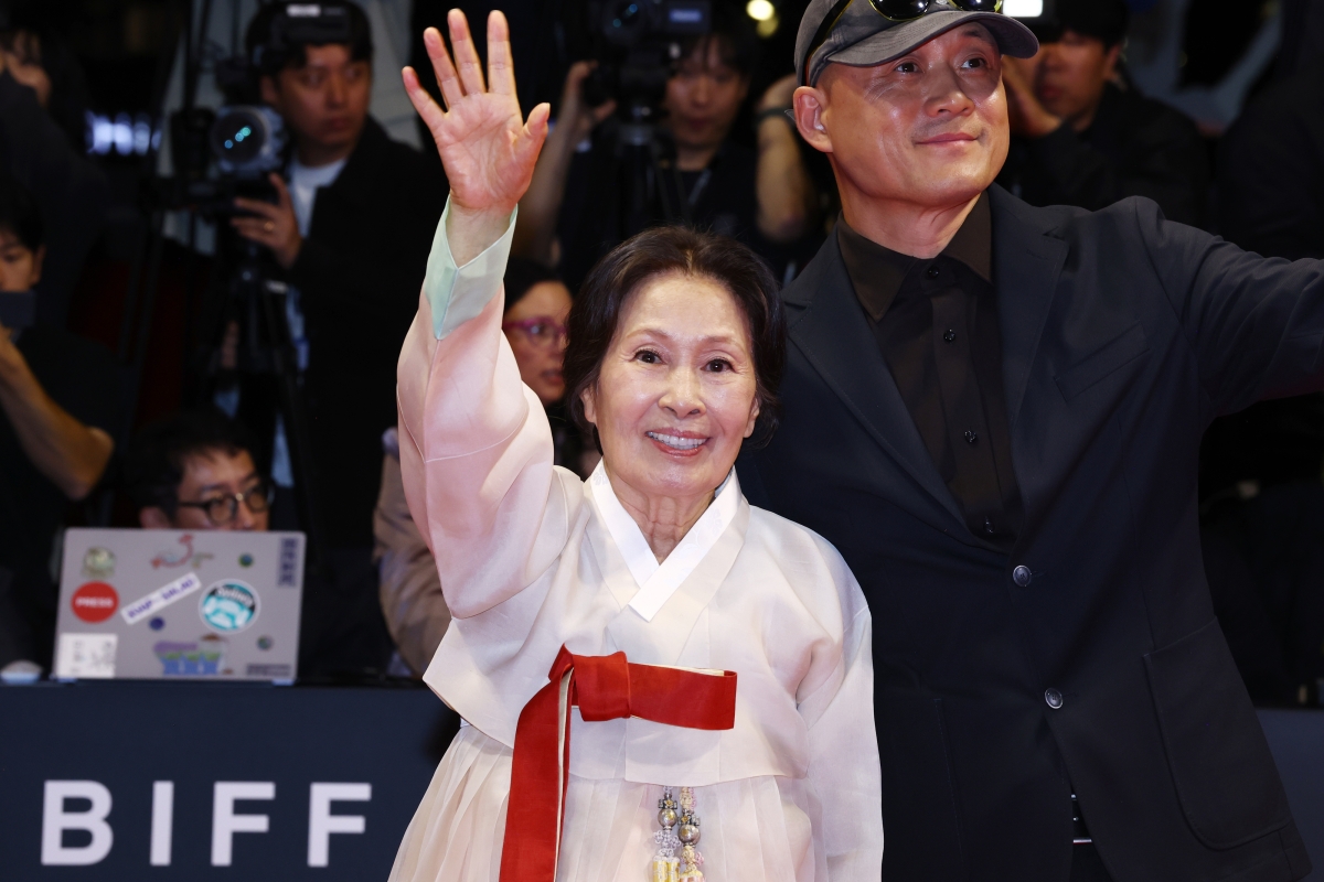 배우 김혜자가 6일 오후 부산 해운대구 영화의전당에서 열린 제31회 부산국제영화제 개막식 레드카펫 행사에서 관람객들을 향해 손을 흔들고 있다. 오른쪽은 김혜자 주연의 영화 ‘여전히 찬란하게’의 송일곤 감독. 2026.10.6 연합뉴스