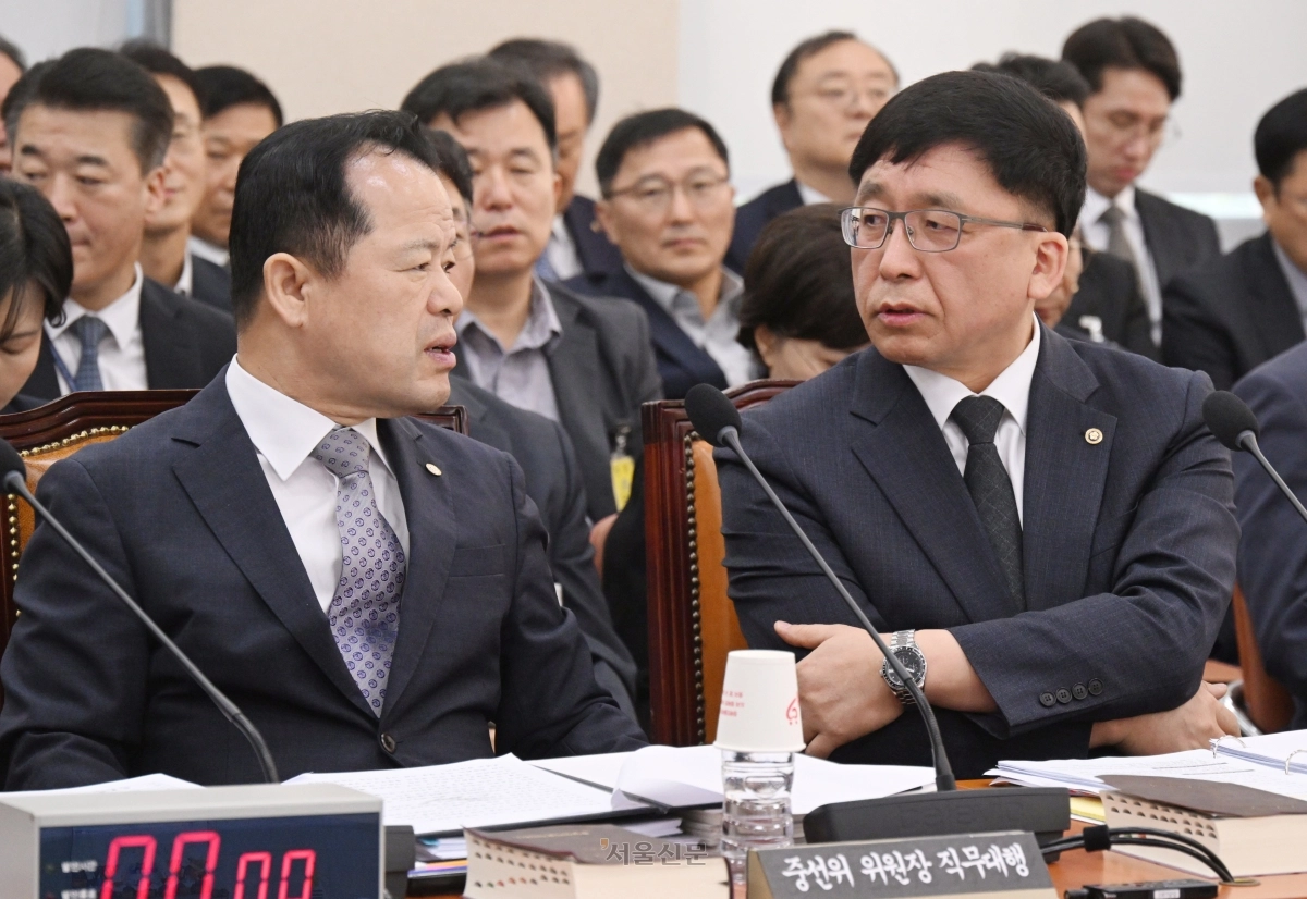 위철환 중앙선거관리위원장 직무대행과 강동완 사무총장 직무대행이 7일  국회에서 열린 행정안전위원회의 중앙선거관리위원회 등에 대한 국정감사에 출석해 대화하고 있다. 2026.10.7 안주영 전문기자