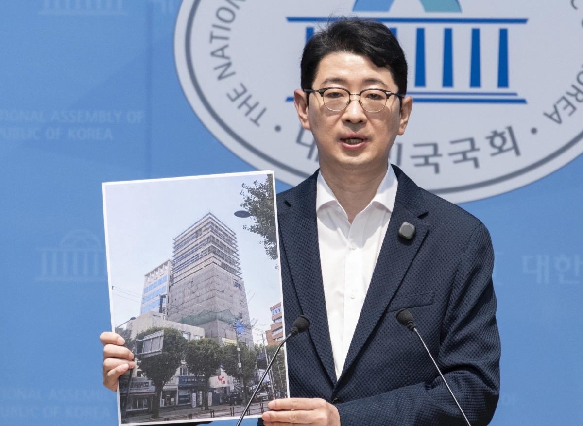 국민의힘 주진우 의원이 4일 국회 소통관에서 가진 기자회견에서 영화 ‘암살자(들)’ 제작사인 하이브미디어코프가 서울 마포구 홍대 앞에 신축 중인 사옥 건립에 한국산업은행과 중소기업은행이 투자한 자금이 활용됐다는 의혹을 밝히며 해당 건물 사진을 들어 보이고 있다. 2026.10.4 연합뉴스