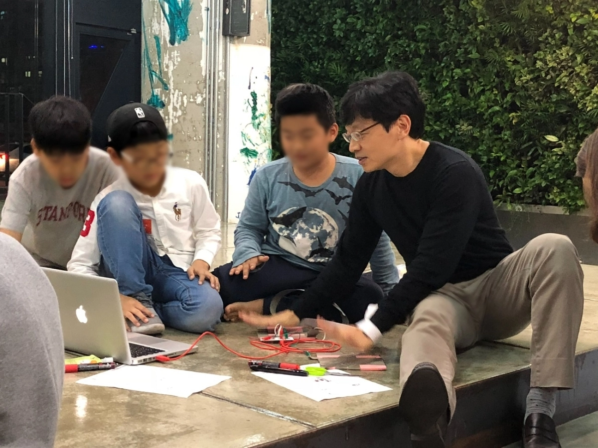 권혁빈(오른쪽 첫번째) 스마일게이트 최고비전제시책임자(CVO)가 최근 경기 성남시 분당구 본사에서 열린 퓨처랩 행사에서 초등학생들이 만든 코딩 프로젝트를 살펴보며 이야기를 나누고 있다. 제공=스마일게이트