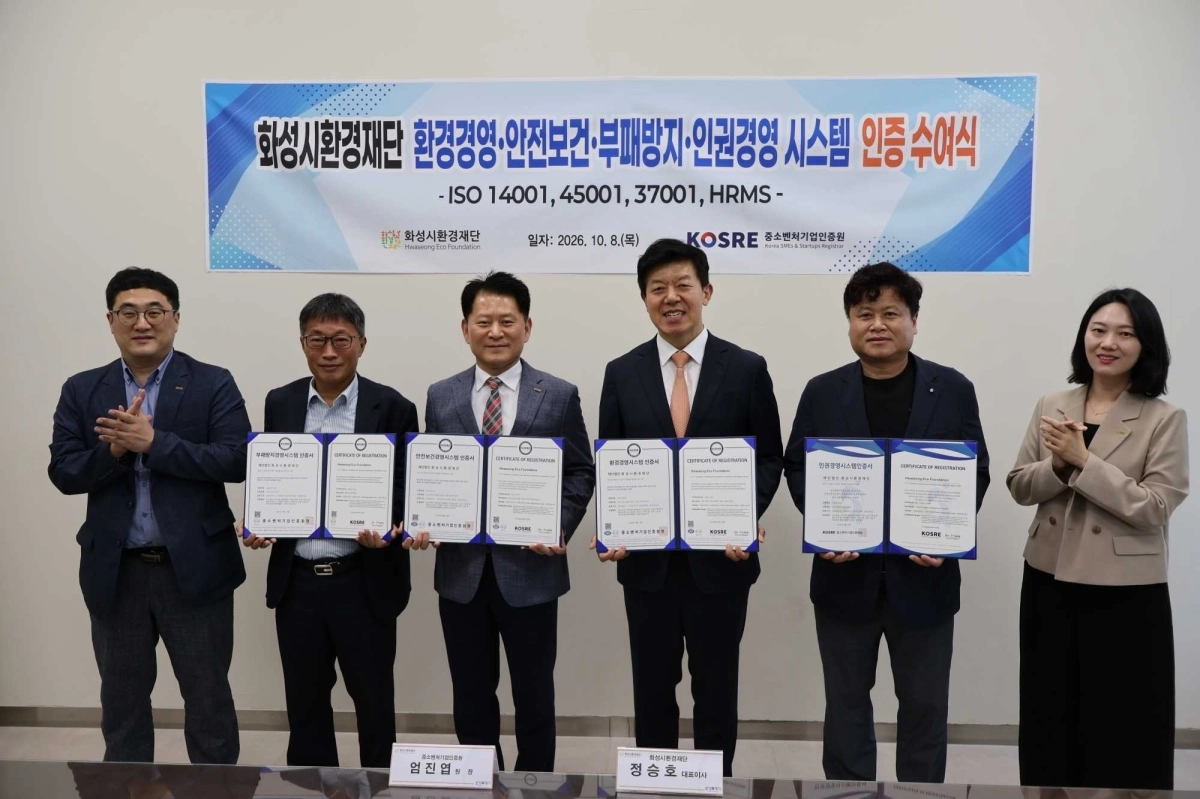 엄진엽(왼쪽 세 번째) 중소벤처기업인증원 원장, 정승호(왼쪽 네 번째) 화성시환경재단 대표이사가 ISO 14001(환경)·45001(안전보건)·37001(부패방지) 및 HRMS(인권경영) 인증 수여식에서 인증서 수여 후 양 기관 주요 관계자들과 함께 기념촬영을 하고 있다. 화성시환경재단 제공