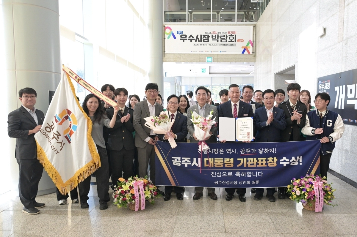 최원철 공주시장과 공무원들이 전통시장 및 상점가 활성화 유공에 따른 대통령 표창을 받은 후 기념사진을 촬영하고 있다. 시 제공