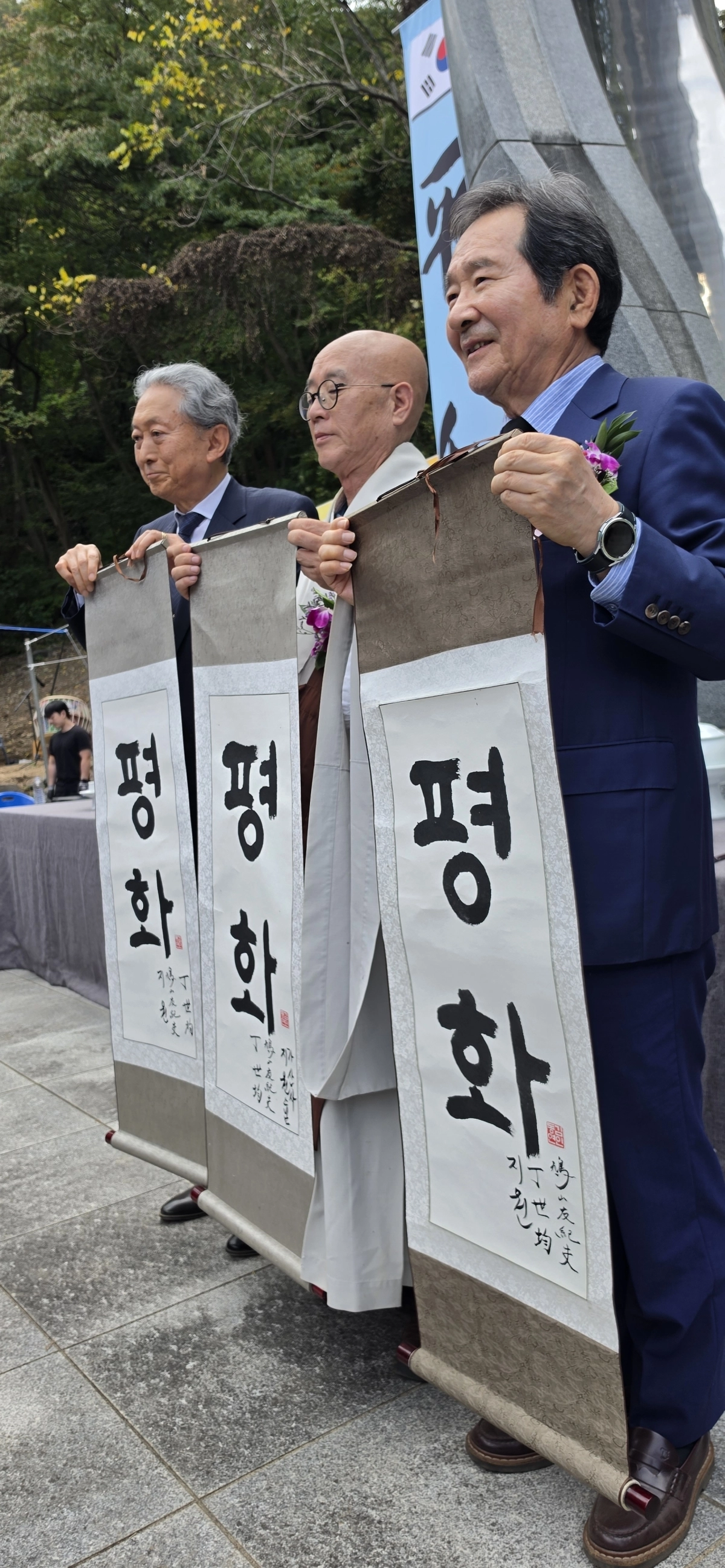 정세균(오른쪽) 전 국무총리와 하토야마 유키오(왼쪽) 전 일본 총리, 가산사 주지 지원스님이 12일 옥천군 안내면 가산사에서 열린 ‘제2회 한일평화의날’ 행사에서 평화라고 쓴 족자를 펼쳐보이고 있다.  가산사 제공.