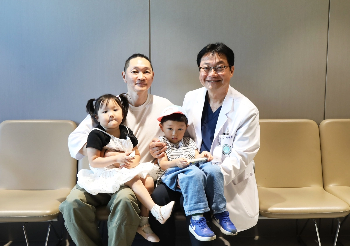 이대비뇨기병원 이동현 교수가 인공방광 수술 후 약 10년간 추적관찰을 받아온 환자, 그리고 두 자녀와 함께 기념촬영을 하고 있다. 이화의료원 제공.