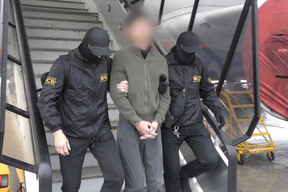 러시아에서 간첩 혐의로 체포된 일본 홋카이도신문 기자가 13일 수갑이 채워진 채 연방보안국 직원에 의해 호송되고 있다. 모스크바 타스 연합뉴스