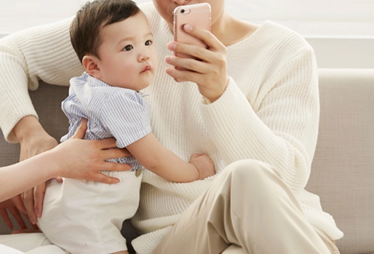 휴대전화를 보고 있는 아기. 아이클릭아트