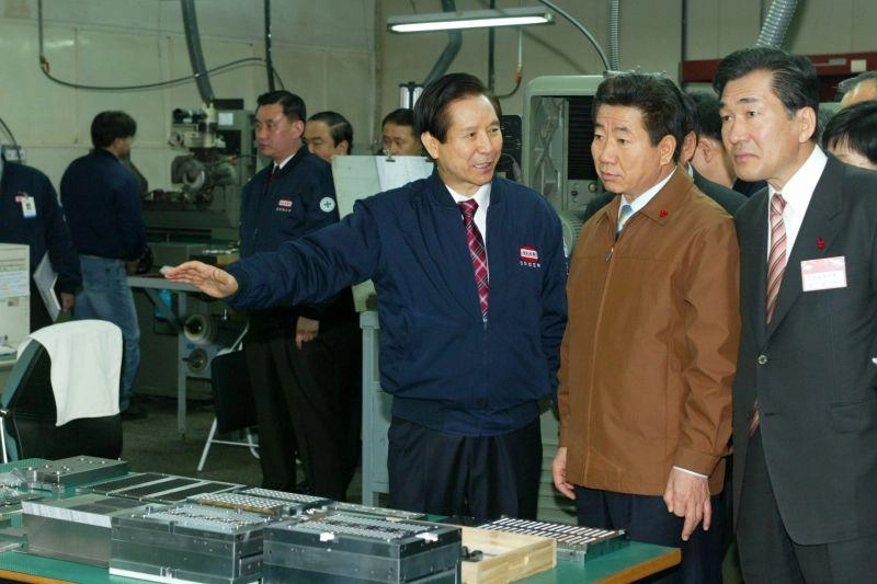 노무현(오른쪽 두 번째) 전 대통령이 2004년 1월 20일 인천 서구 가좌동 한미반도체 공장을 방문해 곽노권(세번 째) 한미반도체 창업주의 설명을 들으며 생산시설을 둘러보고 있다. 노무현아카이브 제공