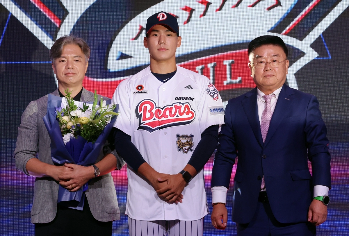 김태룡 전 두산 단장(오른쪽)이 지난달 21일 2027 프로야구 신인드래프트에서 1라운드 2순위로 서울고 김지우를 지명한 뒤 기념사진을 찍고 있다.             뉴시스