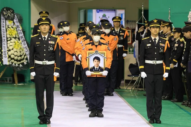 19일 부천 원미구 부천체육관에 열린 ‘고(故) 김진석 소방위 영결식’에서 고인의 운구행렬이 영결식장으로 들어서고 있다. 경기도 제공