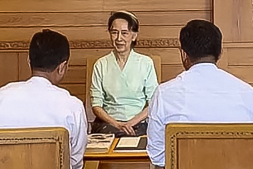 가택연금 중인 아웅산 수치 미얀마 전 국가고문이 19일(현지시간) 수도 네피도 구금 장소에서 내무부 관리들로부터 영국 찰스 3세 국왕이 보낸 서한과 선물을 전달받고 있다. 네피도 AFP 연합뉴스