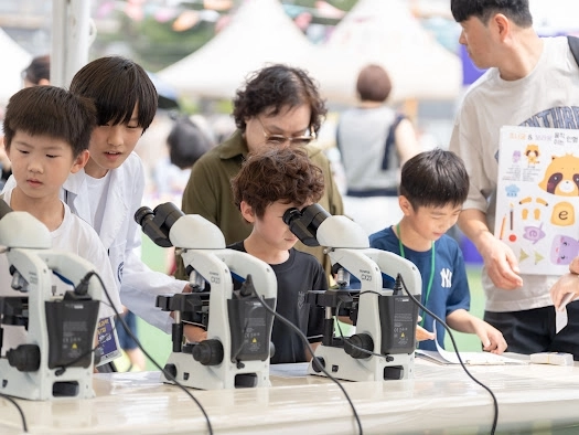 지난해 6월 서울 동작구 노량진축구장에서 열린 ‘동작 미래과학 페스티벌’에서 어린이들이 진지한 표정으로 현미경을 들여다 보고 있다.  동작구 제공