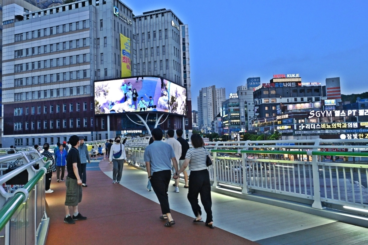 전남광주통합특별시 남구의 새 중심지로 떠오른 백운광장 일대. 시민들이 푸른길브릿지를 걸으며 남구청사 외벽에 설치된 초대형 미디어월의 영상을 감상하고 있다.  전남광주시 남구 제공