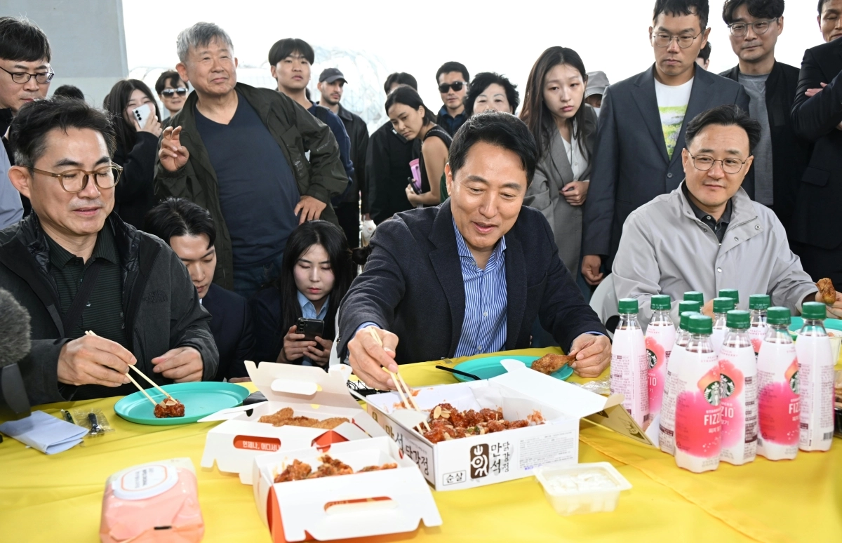 오세훈(가운데) 서울시장이 25일 열린 ‘2026 차 없는 잠수교 뚜벅뚜벅 축제’ 마지막 행사에서 치킨을 시식하고 있다. 서울시 제공