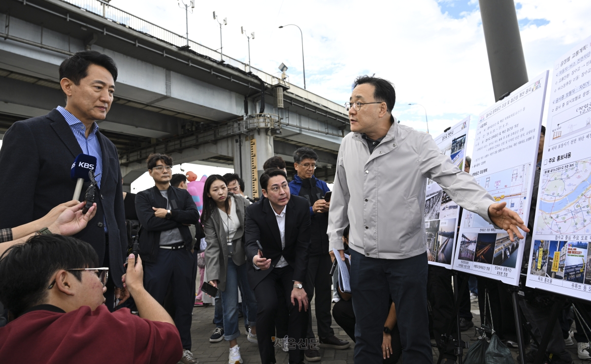 오세훈(왼쪽) 서울시장이 25일 서울 서초구 잠수교 인근에서 관계자로부터 잠수교 보행전용교 전환 관련 브리핑을 듣고 있다. 잠수교는 오는 26일부터 차량 통행을 전면 통제하고 한강 보행전용교 조성을 위한 공사에 들어간다. 2026.10.25 이지훈 기자