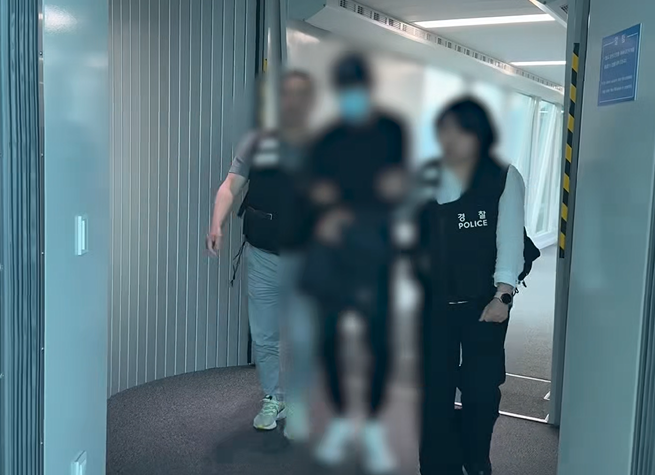 경찰이 중국에서 보이스피싱 총책 A씨를 검거해 국내로 압송하고 있다. 부산경찰청 제공